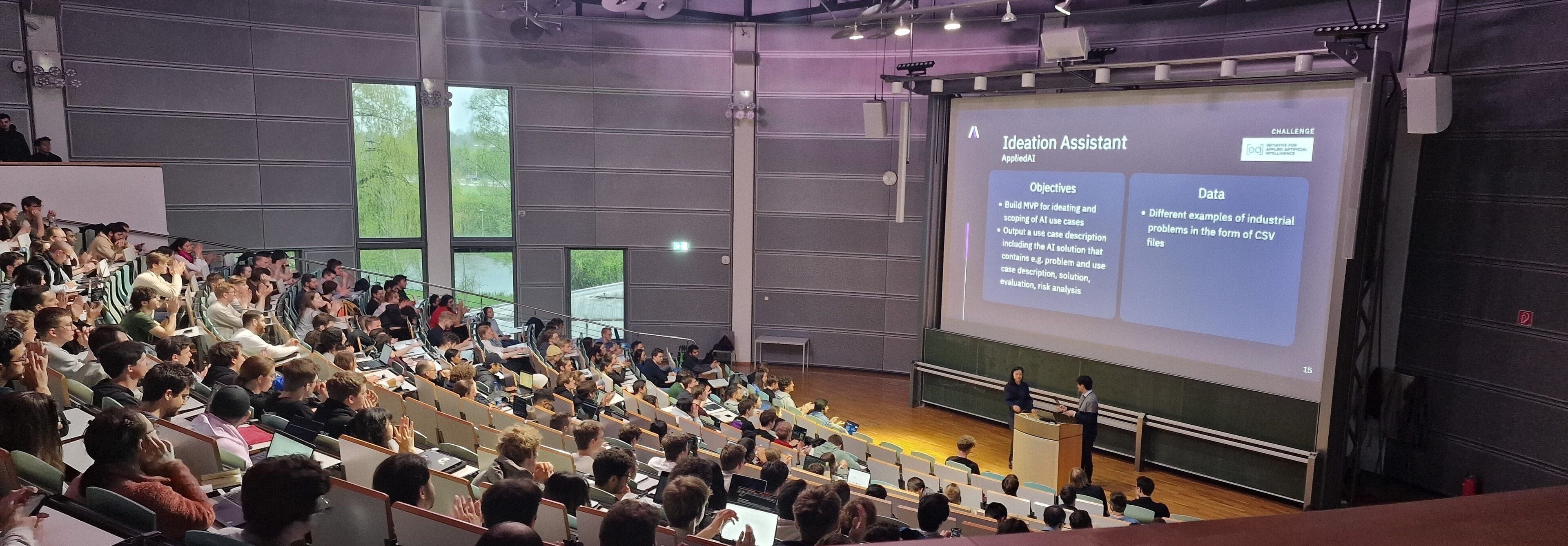 A packed lecture hall watching a team present an appliedAI challenge